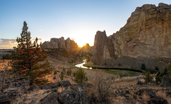 View on red rock faces with Crooked River, last sunrays behind rocks at sunset, Smith Rock State Park, Oregon, USA