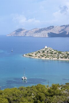 View of sailing boats and old windmill in Panormitis Bay, Symi, Dodecanese, Greece