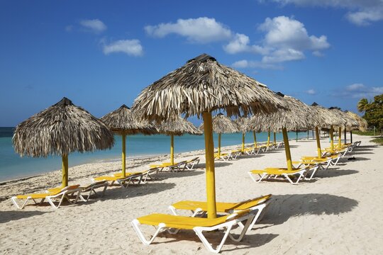 Sunbeds and thatched parasols at the Playa Anc&oacute;n beach, Trinidad, Cuba