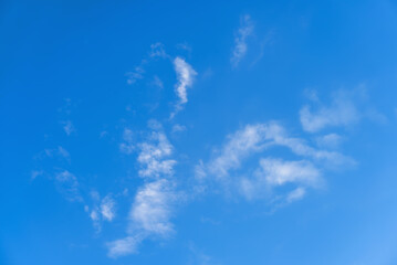 Clear blue sky background with soft white clouds on a sunny day. Natural bright heaven landscape for weather and summer outdoor concept. © Pat