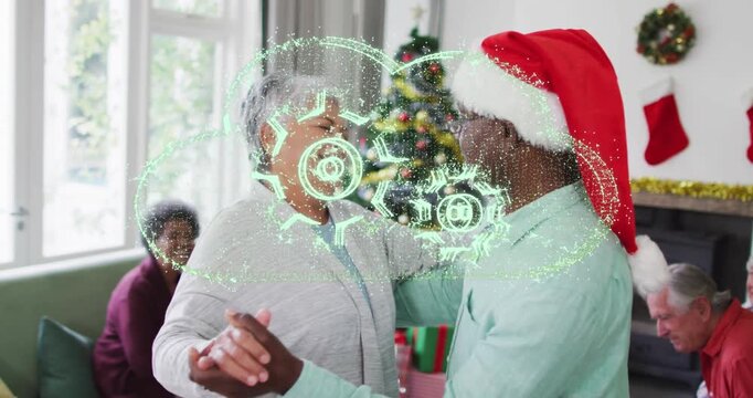 Animation of cloud icon over african american senior couple dancing at home during christmas
