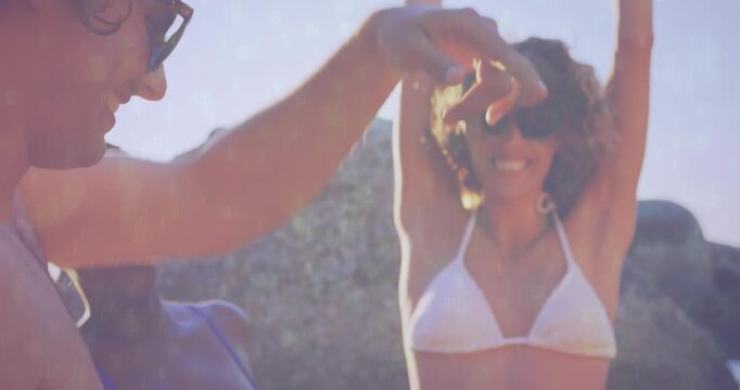 Friends arriving at shore in sun sparking dancing with headphones swinging for lifestyle marketing