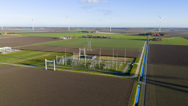 Aerial view of Windplan Groen wind farm and an electrical substation surrounded by agricultural fields in Dronten, Flevoland, Netherlands.