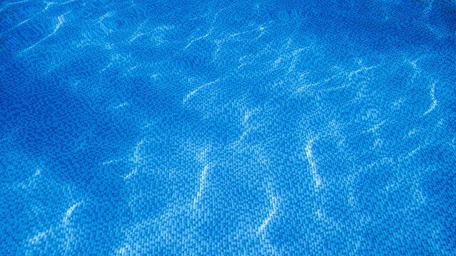 Background picture. Swimming pool bottom ripple and with waves background. Rippling blue water in swimming pool with blurry tile pattern at the bottom.