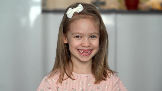 Portrait of little happy toothless child looks at camera and laughs. Baby milk teeth change. Child kid