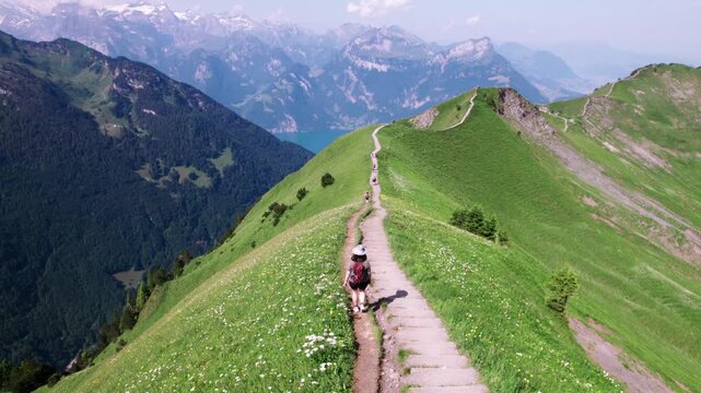 Aerial shot of Stoos Ridge hiking trail, lush green alpine landscape, mountain peaks, summer adventure, nature travel, Switzerland drone 4k footage.