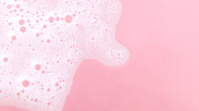 White soap foam bubbles on pink background, skincare cleansing and hygiene concept
