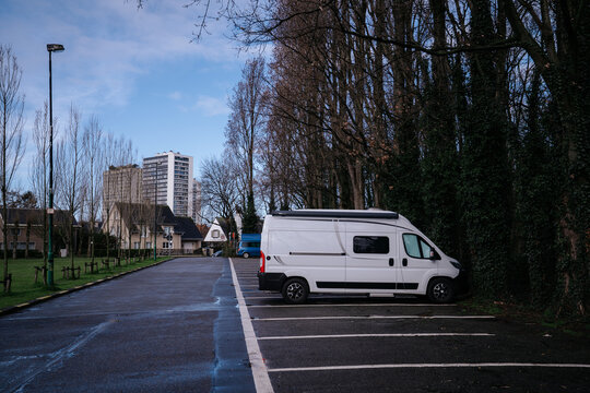 White converted camper van parked in an urban parking lot, Belgium