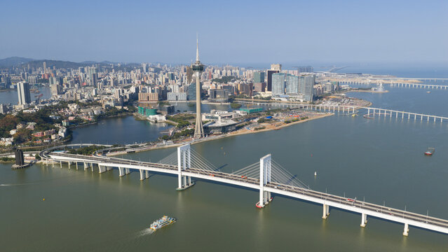 Macao, Macao - 16 February 2026: Aerial view of Ponte de Sai Van bridge and the Macau Tower skyline under a clear blue sky.