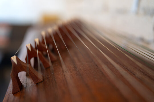 Close-Up of Traditional Chinese Guzheng Zither Strings and Wooden Bridges