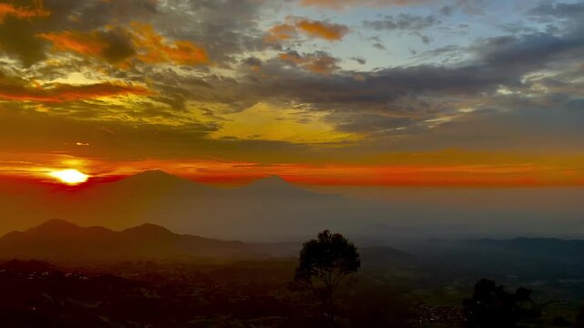 Dramatic golden sunrise over Mount Sumbing and tropical valley