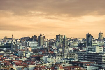 Fototapeta premium Skyline of Porto at dusk showcases a blend of modern and historic buildings. Digital nomads adapt to rising living costs and a shifting housing market in this vibrant city