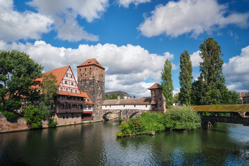 Obraz premium Panoramic view of the Pegnitz river featuring the Henkersteg bridge and the half-timbered Weinstadel in Nuremberg, Bavaria, Germany.