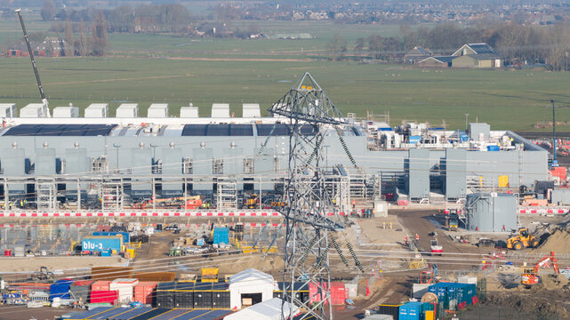 Groningen, Netherlands - 20 January 2026: Aerial view of Datacenter Westpoort under construction with power lines, heavy machinery, and surrounding green fields.