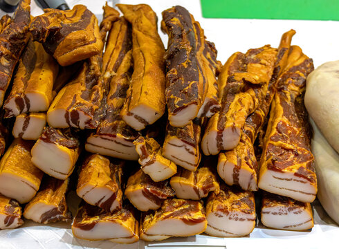 Stack of organic homemade cured pork bacon sold outside on local market