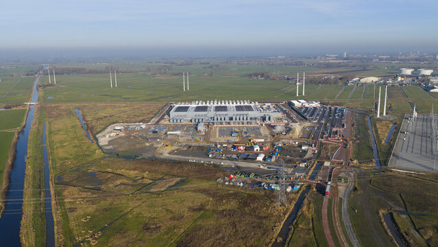 Groningen, Netherlands - 20 January 2026: Aerial view of Datacenter Westpoort featuring the large industrial facility surrounded by green fields and a long canal.