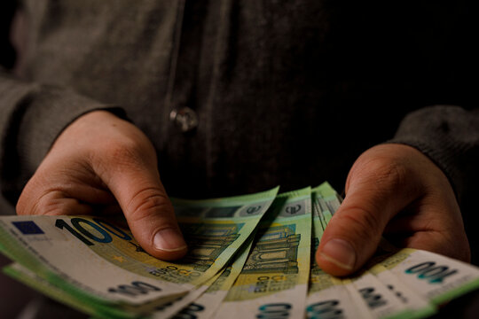 Close-up of hands holding euro banknotes. Money, finance, wealth, business concept.