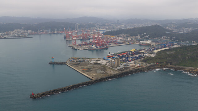 Keelung City, Taiwan - 20 February 2026: Aerial view of the port's industrial heart, where colossal red cranes stand like giants against the misty skyline.