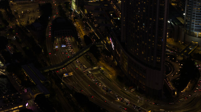 Hong Kong, Hong Kong - 13 February 2026: Aerial view of the gleaming International Finance Centre amidst the dark, vibrant cityscape, with streams of car lights.