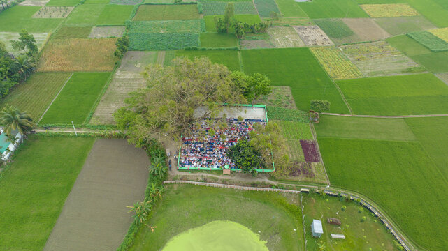 Muslim community gathering for eid or friday prayers in a rural village, men bowing and prostrating on mats