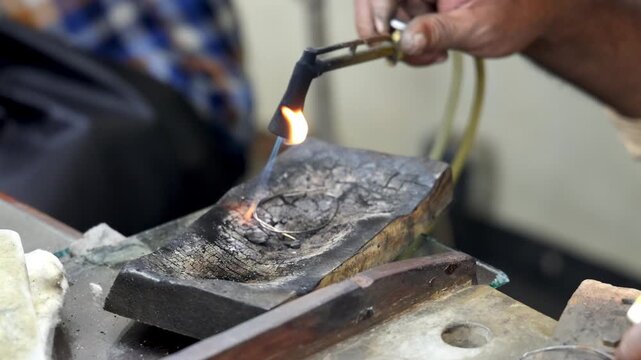 Master Artisan Melds Precious Metal with Fiery Torch: Detailed Closeup of Jewelry Making Process in Traditional Workshop Setting. Sri Lanka island, Asia.