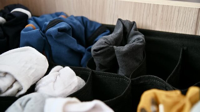 Colorful socks organized in fabric storage bin, visible textures and patterns