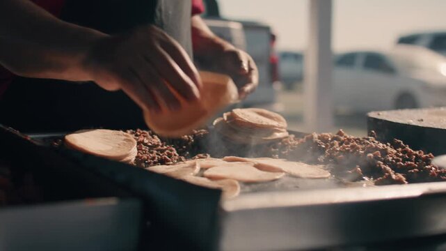 Cook Moving Meat and Tortillas Around on Grill While Cooking Outdoors