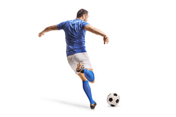 Rear view shot of a football player in a blue jersey kicking a ball © Ljupco Smokovski