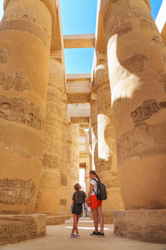  Egypt - karnak hypostyle hall columns in the temple at luxor thebes and happy tourist girls - mother and daughter on vacation.