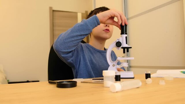Boy bends close to a microscope beside jars and tools, natural lifestyle scene with negative space. At home research keeps kids engaged and builds science literacy for healthier decisions.