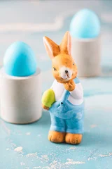 Cute decorative Easter bunny and blue easter eggs on a blue background © Daniela Baumann