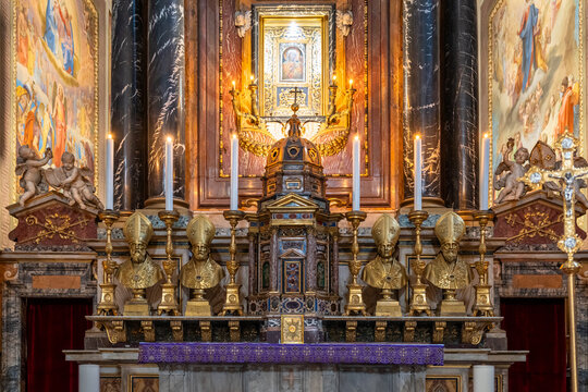 Golden statues of popes, candlesticks and a canopy in miniature decorating altar inside Saint Augustine church in Rome