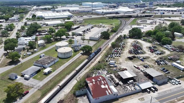 Train on Track In Industrial Area Near Car Junkyard