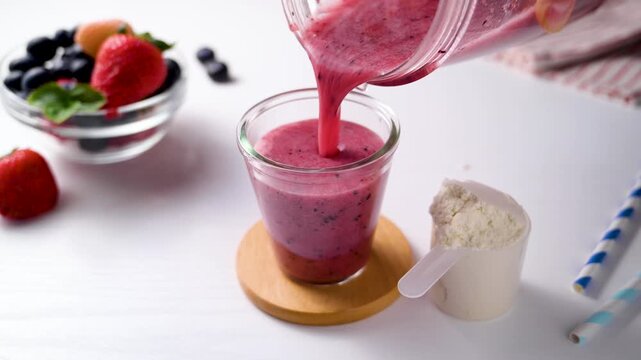 Pouring berry smoothie made from fresh fruits and berries, healthy eating 