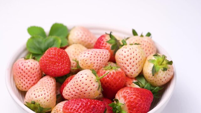 Strawberry red and white berry fruits in a bowl, isolated, abstract food background, top view with copy space