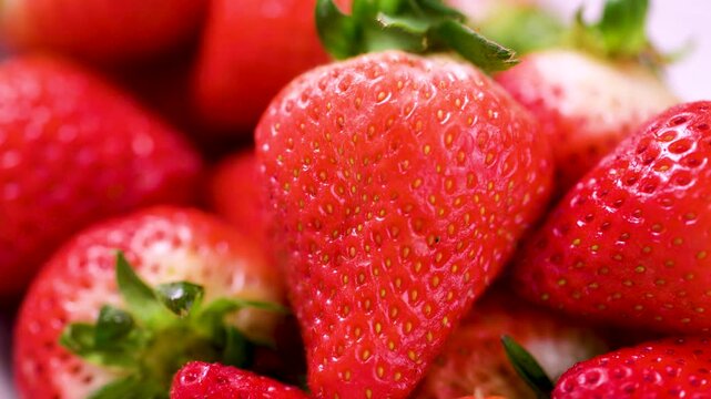 Strawberry red berry fruits in a bowl, isolated, abstract food background, close-up shot