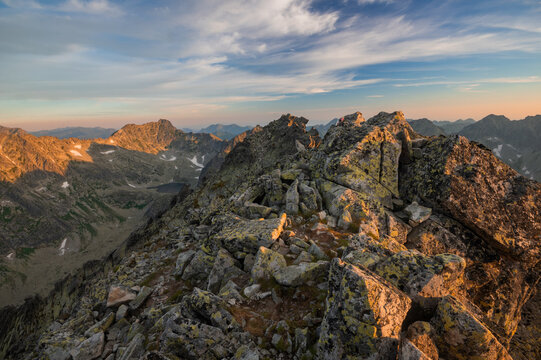 View of rugged, moss-covered rocks cascade down the mountain, bathed in the warm glow of the setting sun, Vysoke Tatry, Presovsky kraj, Slovakia.