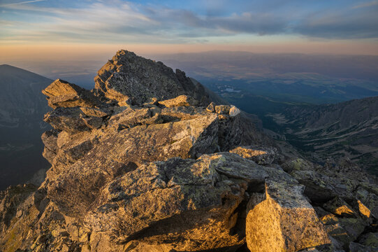 View of jagged rocks glow under the warm kiss of the setting sun, casting long shadows across the mountainous terrain, Vysoke Tatry, Presovsky kraj, Slovakia.
