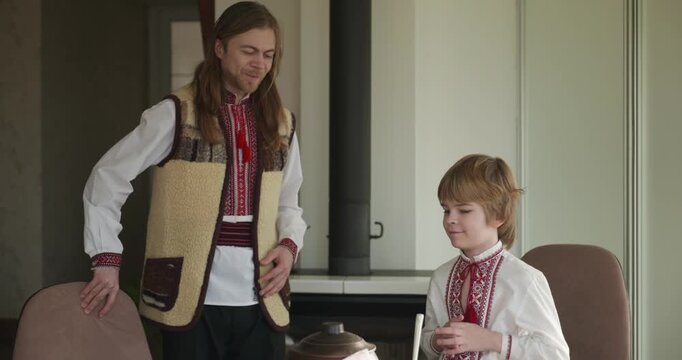 Man With Kid Boy Praying Before Dinner. Family in Ukrainian Traditional Attire Childhood. 4K 10-bit
