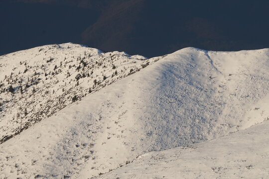 Aerial view of the snow-laden slopes of Dumbier, a winter wonderland under a brooding sky, Nizke Tatry, Zilina Region, Slovakia.