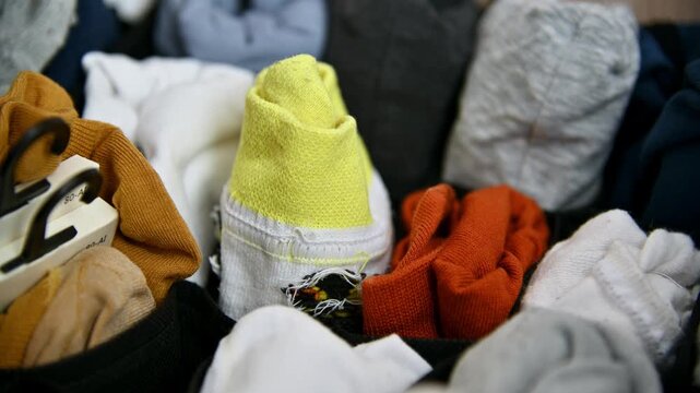 Hand sorting colorful socks in a basket, organizing by color and type