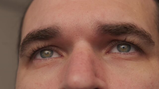 Closeup Upward Gaze Of Hopeful Man, Greenish Iris Catching Light, Raised Brow And Soft Expression Evoking