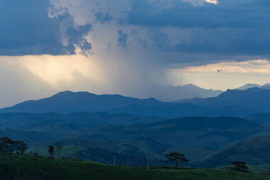 Rain Showers Falling Over Distant Mountains Beneath Dramatic Cloudy Sky