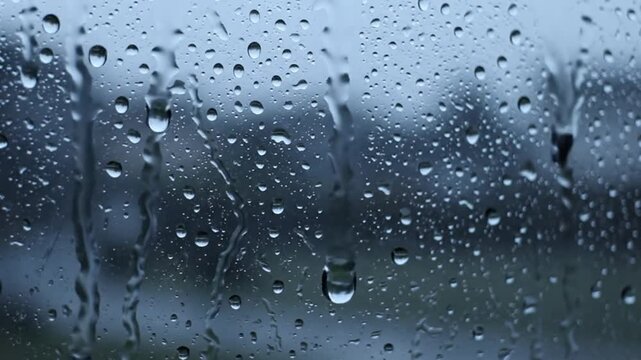 Raindrops Flowing Down the Glass of a Window in a Close Up, Revealing a Serene Atmospheric Scene