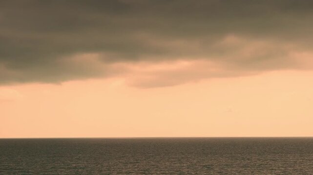 Bay beach and yellow evening sky rain black thunderclouds time lapse, motion. Calm ocean, colorful tropical sunset skyscraper dark clouds 4K timelapse horizon, travel  vacation, sea sky black cloud.