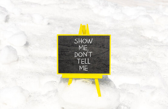 Tell or show symbol. Concept words Show me, do not tell me on beautiful black blackboard. Beautiful white snow background. Business tell or show concept. Copy space.