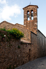 Fototapeta premium Montalcino bell tower and narrow street, Tuscany, Italy.