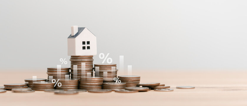 Real estate investment, mortgage interest rate, home loan  and personal finance property wealth Concept. Small  house model on stacks of coins with rising percentage icons and bar charts.