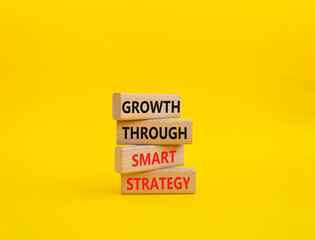 Naklejka premium Smart strategy symbol. Wooden blocks with words Growth through smart strategy. Beautiful yellow background. Business and Smart strategy concept. Copy space