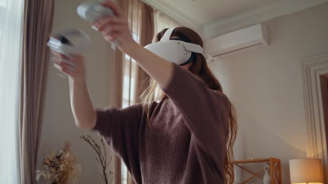 Woman lifts controllers high during intense VR game at home
